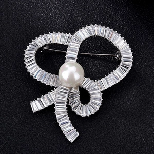 Luxurious silver bow brooch with pavé zircon crystals and a central white pearl detail