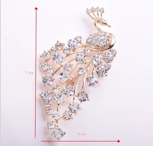 Detail showing peacock brooch dimensions at 7.5cm by 4.8cm with sparkling crystals