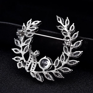 Silver flower wreath brooch with sparkling crystals showing back pin mechanism detail