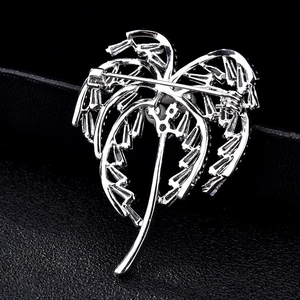 Élégante broche palmier en argent sertie de zircons blancs sur un fond noir texturé