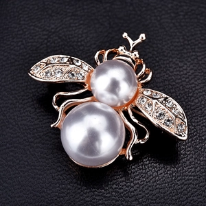 Détail macro de broche abeille avec perles blanches et ailes en cristal sur cuir noir