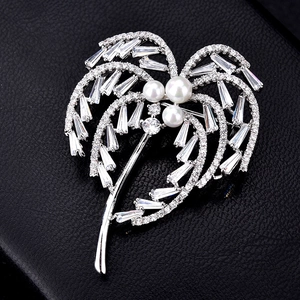 Broche cocotier élégante en argent avec zircons brillants et perles sur fond noir texturé