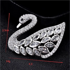 Detailed view of silver swan brooch with white crystals measuring 3.5cm by 4.3cm