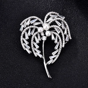 Broche palmier élégante ornée de zircons brillants et perles blanches sur fond noir