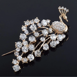 Close-up of elegant peacock brooch with sparkling crystal rhinestones and gold alloy base