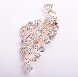 Close-up detail of golden peacock brooch with sparkling inlaid rhinestones and intricate patterns