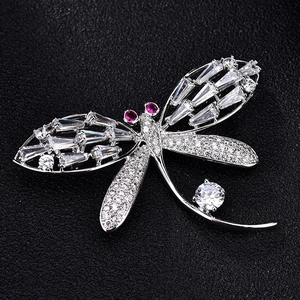 Luxurious dragonfly brooch with sparkling crystals and red gems on black leather