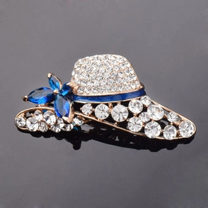 Detail of gold sun hat brooch with white rhinestones and blue enamel floral accents