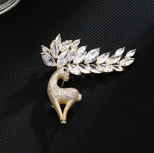 Macro shot of gold reindeer brooch with marquise-cut crystals on a textured background