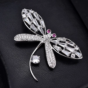 Macro detail of luxury dragonfly brooch with cubic zirconia crystals on black leather