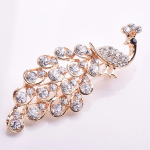 Detailed close-up of golden peacock brooch with sparkling crystal rhinestones and dark eye