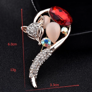 Detailed view of fox brooch with cat eye stones and red gemstone, 6.0cm by 3.3cm size