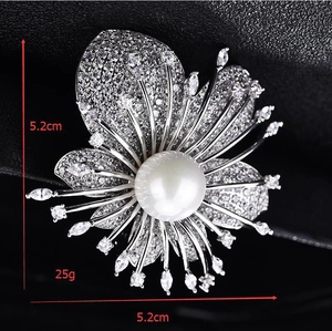 Detail showing 5.2cm flower brooch with shimmering zircons and central pearl accent