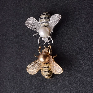 Exquisite Bienenbroschen mit funkelnden Zirkonen und Perlen auf schwarzem Leder