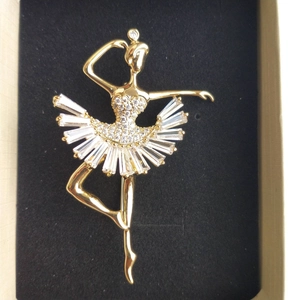 Détail d'une luxueuse broche ballerine en plaqué or avec des pierres en zircone