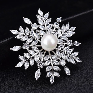 Détail d'une broche flocon de neige avec perle centrale et cristaux de zircone scintillants