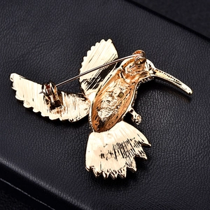 Detailed back view of golden hummingbird brooch pin with intricate feather textures