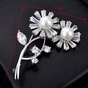 Detail view of flower brooch with baguette crystals and large imitation pearls