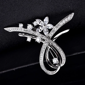 Broche fleur argentée élégante avec cristaux de zircone sur une surface noire texturée