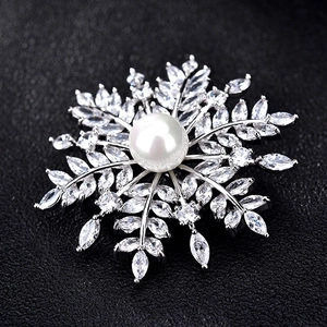 Détail de la broche flocon de neige avec perle blanche et zircons étincelants