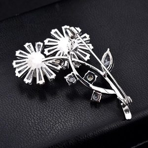 Silver daisy flower brooch with sparkling crystals and twin floral design on black leather