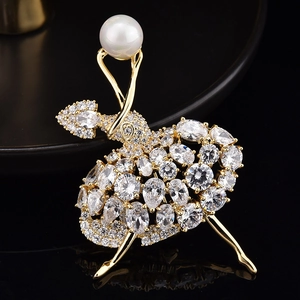 Détail de la broche ballerine dorée ornée de zircons brillants et d'une perle blanche