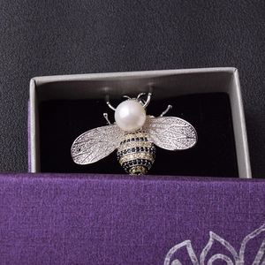 Detailaufnahme einer Bienenbrosche mit Perlenkopf und kristallbesetzten Flügeln