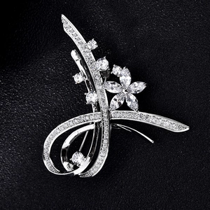 Broche fleur argentée élégante avec pierres de zircone sur un fond noir texturé