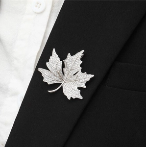 Luxury maple leaf brooch with zircons on a black blazer, elegant silver jewelry accessory