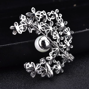 Elegante zilveren broche met zirkoon en witte parel in de vorm van een maankrans