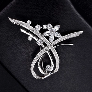 Vue détaillée d'une broche fleurie argentée sertie de zircons sur fond de cuir noir