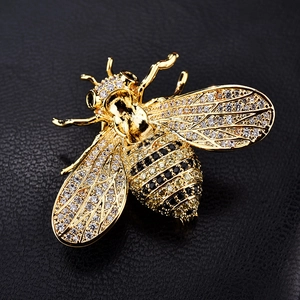 Detailansicht der goldenen Bienenbrosche mit funkelnden Kristallen und gelben Steinen