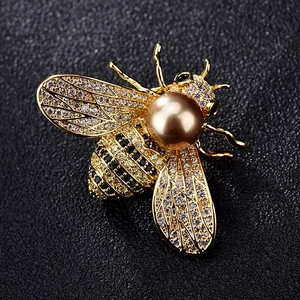 Makroaufnahme einer Bienenbrosche mit Zirkonia-Flügeln und großer Champagner-Perle