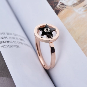 Elegante roségouden draaiende sterring met zwarte pentagram inleg op een minimalistische band