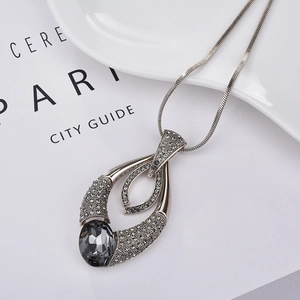 Detail of silver long sweater necklace with teardrop pendant and grey crystal inlay