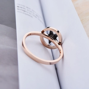 Moderne roségouden draaibare ring met hol rond frame en zwarte sterbedel