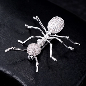 Elegant silver ant brooch with sparkling cubic zirconia on a black leather background