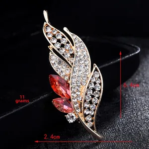 Detailed view of luxury leaf brooch with crystal rhinestones and red gems showing 6.4cm size