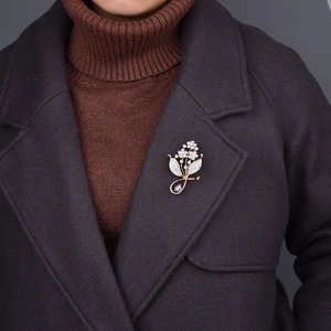 Elegant flower cluster brooch with purple teardrop gem and rhinestones on coat lapel
