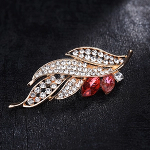 Elegant gold leaf brooch set with sparkling white crystals and pink marquise gems