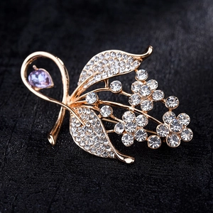 Elegant floral brooch with gold plating, white rhinestones, and purple teardrop crystal