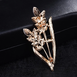 Detail of the golden leaf brooch back showing the pin fastener and metal texture