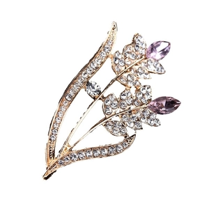 Elegant gold flower brooch with purple pear-shaped stones and white rhinestones