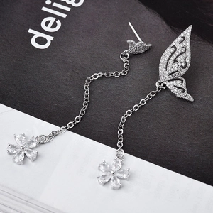 Boucles d'oreilles papillon argentées asymétriques avec ailes en zircon et pompons