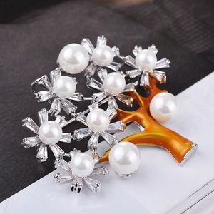 Dettaglio macro della spilla albero della fortuna con perle bianche e zirconi brillanti