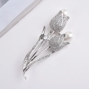 Detailed macro view of silver tulip brooch with pavé zircon petals and white pearls