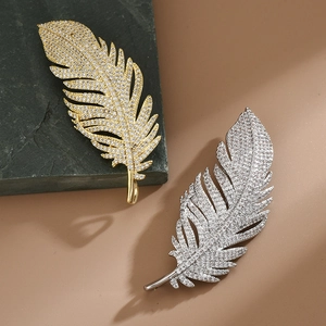 Detail showing elegant gold and silver feather brooches with micro-set cubic zirconia