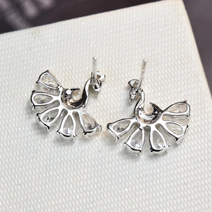 Macro view of S925 silver peacock stud earrings featuring sparkling water-drop zircon stones