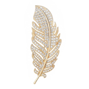 Detailed view of feather brooch with gold metal and shimmering white zircon stones