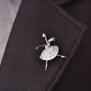 Détail d'une luxueuse broche ballerine avec zircons sur le revers d'un manteau foncé
